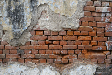 Oprýskaná cihlová stěna