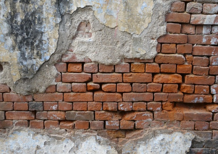 Oprýskaná cihlová stěna